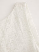 Woman wearing an ivory boat-neck mini dress with a knotted backless detail