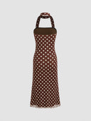 Woman wearing a chocolate polka dot midi dress with a halter choker neckline