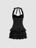 Woman wearing a black polka dot mini dress with a tiered ruffle skirt