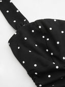 Woman wearing a black polka dot mini dress with a tiered ruffle skirt