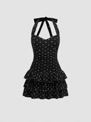 Woman wearing a black polka dot mini dress with a tiered ruffle skirt