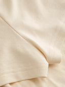 Woman wearing a butter yellow halter mini dress with an open back