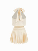 Woman wearing a butter yellow halter mini dress with an open back