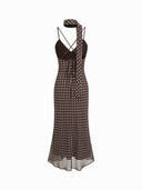 Woman wearing a dark brown polka dot midi dress with a matching scarf
