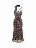 Woman wearing a dark brown polka dot midi dress with a matching scarf