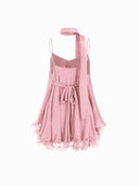 Woman wearing a pink tiered ruffle mini dress with a matching scarf