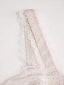 Woman wearing a blush ditsy floral corset midi dress with a lace-up back