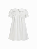 Woman wearing a white babydoll mini dress with a Peter Pan collar and puff sleeves
