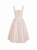 Woman wearing a blush ditsy floral corset midi dress with a lace-up back