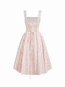Woman wearing a blush ditsy floral corset midi dress with a lace-up back