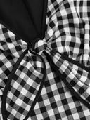 Woman wearing a black gingham mini dress with a twist-knot detail