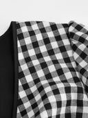 Woman wearing a black gingham mini dress with a twist-knot detail