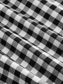 Woman wearing a black gingham mini dress with a twist-knot detail