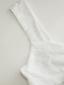 Woman wearing a floral lace mini dress with a sweetheart neckline