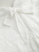 Woman wearing a floral lace mini dress with a sweetheart neckline