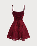 Woman wearing a wine red floral jacquard mini dress with a lace-up back