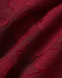 Woman wearing a wine red floral jacquard mini dress with a lace-up back