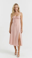 Woman wearing a rosé corset midi dress with lace-up detailing