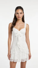 Woman wearing a floral lace mini dress with a sweetheart neckline