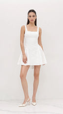 Woman wearing a white dress against a plain background