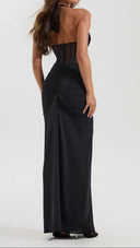 Woman wearing a black ruched maxi skirt, close-up of the ruched waist