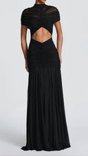Woman wearing a black ruched cape maxi dress, close-up of the cape and neckline