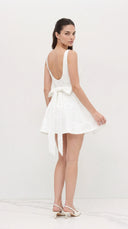 Woman wearing a white dress with a bow detail on a white background