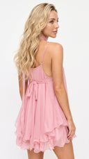 Woman wearing a pink dress with a white background
