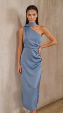 Woman wearing a blue one-shoulder dress against a beige wall