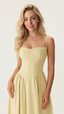 Woman wearing a light yellow dress against a white background