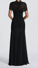 Woman wearing a black ruched cape maxi dress, close-up of the diamond cutout bodice