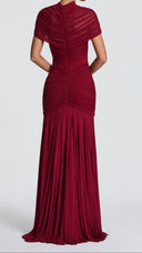 Woman wearing a burgundy ruched cape maxi dress, close-up of the cape and neckline