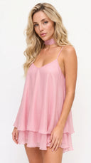 Woman wearing a pink dress with thin straps on a white background
