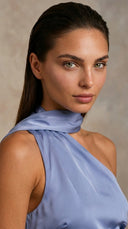 Woman wearing a light blue sleeveless top against a neutral background