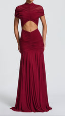 Woman wearing a burgundy ruched cape maxi dress, back view