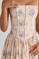 Woman wearing a blush floral corset midaxi dress